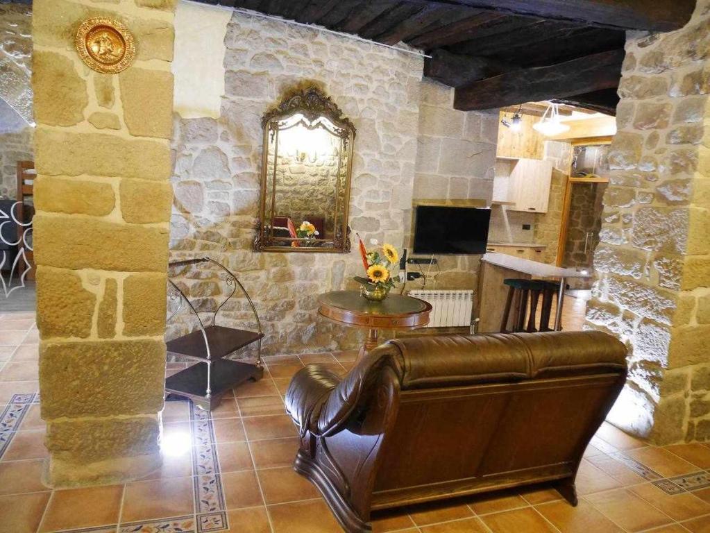 un soggiorno con divano in pelle e tavolo di El Bressol de Cal Feixas Preciosa casa rural de época a Freixinet