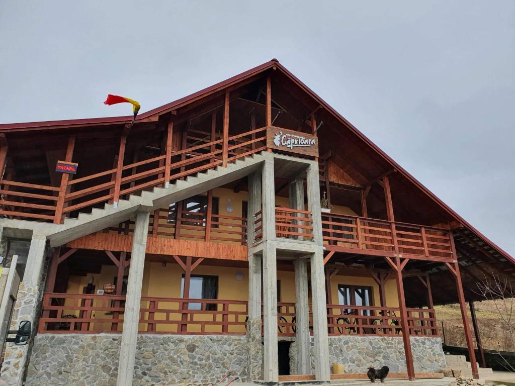 a large wooden building with a large balcony at Agropensiunea Căprioara in Mintia