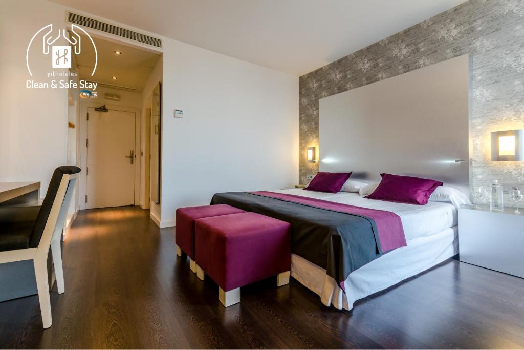 a bedroom with a large bed with purple pillows at YIT Vía Sevilla Mairena in Mairena del Aljarafe