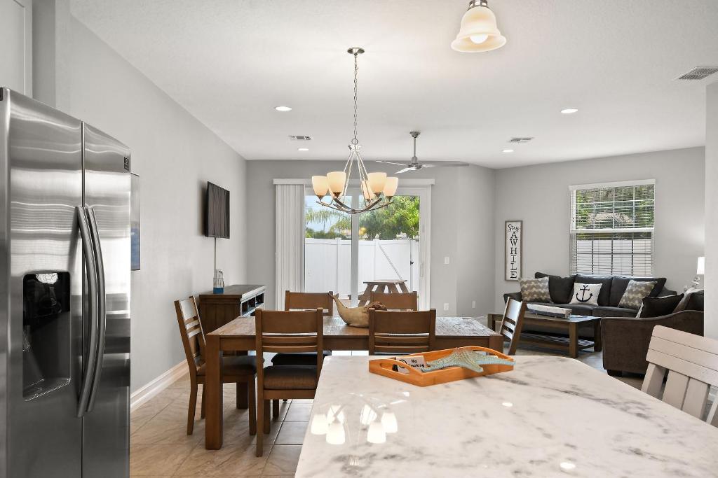 a kitchen and living room with a table and a refrigerator at Fortebello Beachside - 156 in Indian Harbour Beach