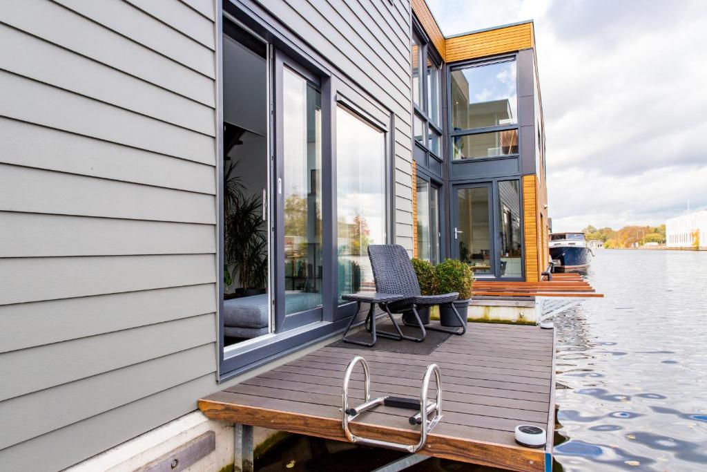 a house on a dock with a chair on it at Willem de Zwijgerlaan Luxury Ark in Amsterdam