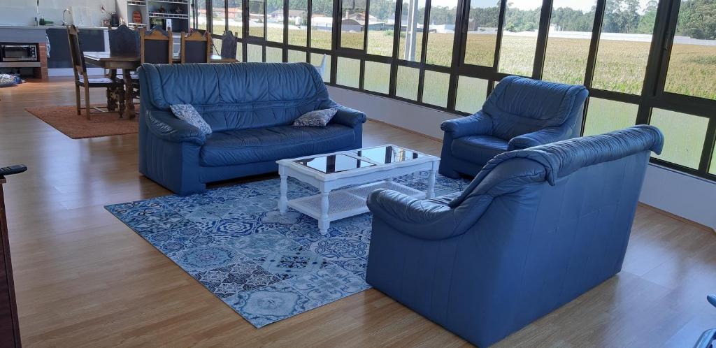 2 blaue Stühle und ein Couchtisch im Wohnzimmer in der Unterkunft Lourenço House in Póvoa de Varzim
