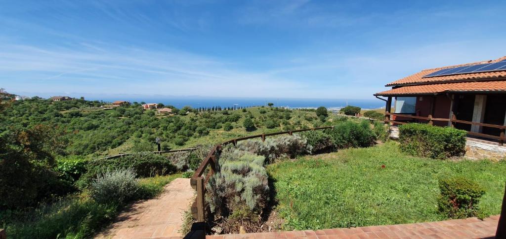 a house on a hill with the ocean in the background at Hotel Tenuta dell'Argento Resort in Civitavecchia