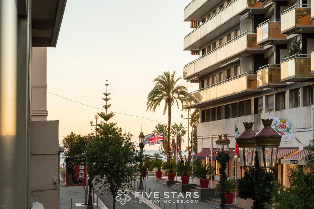 une rue devant un immeuble avec des palmiers dans l'établissement Studio Massenet Five stars holiday house, à Nice