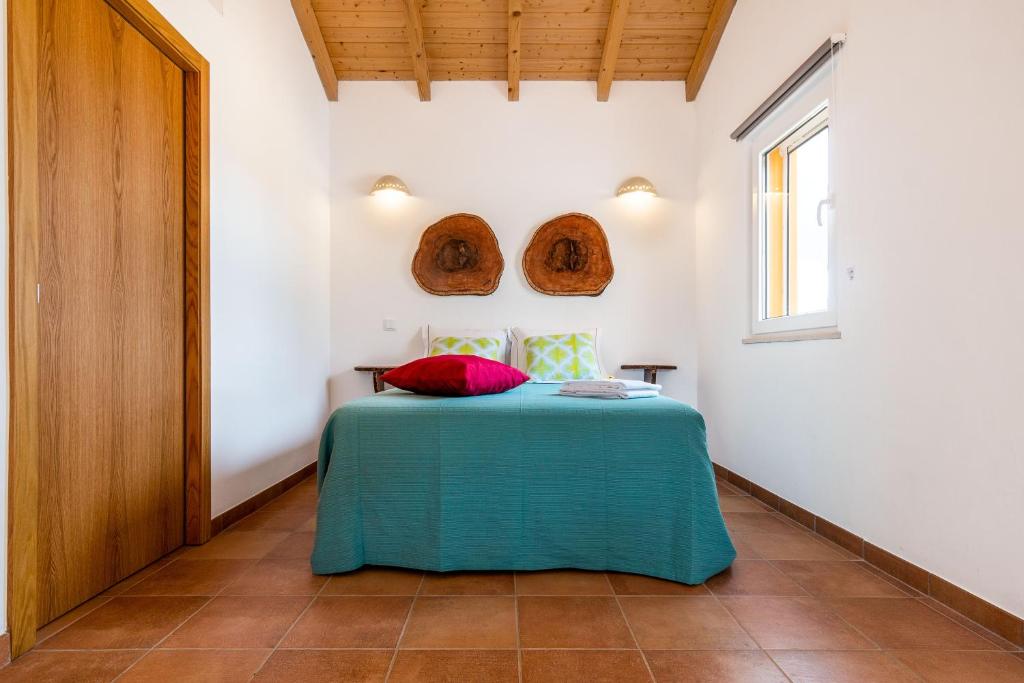 1 dormitorio con 1 cama con manta verde y ventana en Monte dos Cachoupos, en São Luis