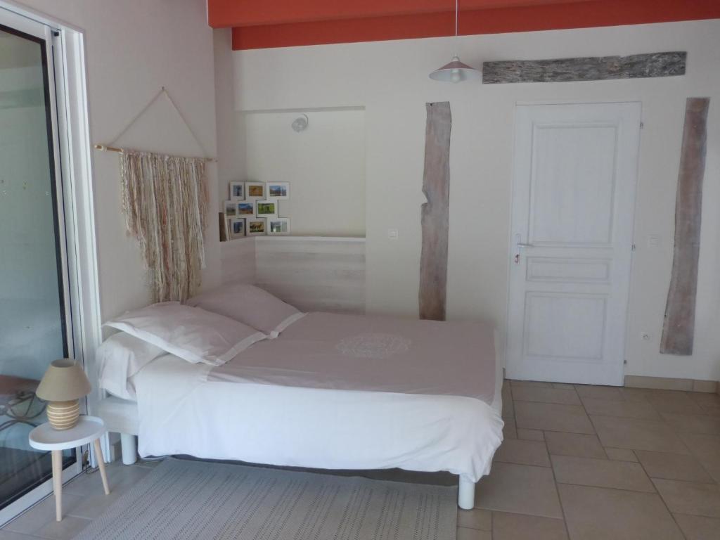 um quarto com uma cama branca e uma porta em L'EPICERIE em Pau