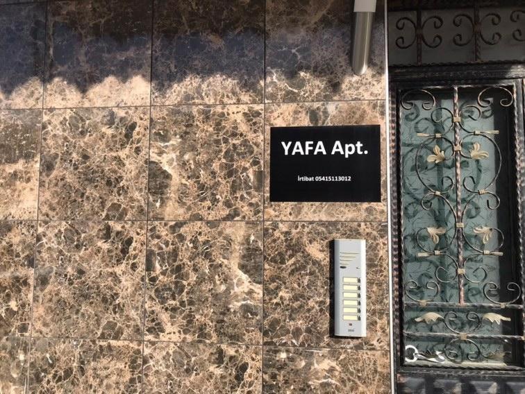 a sign on the side of a building with a door at YAFA Furnished Apartments Trabzon in Trabzon