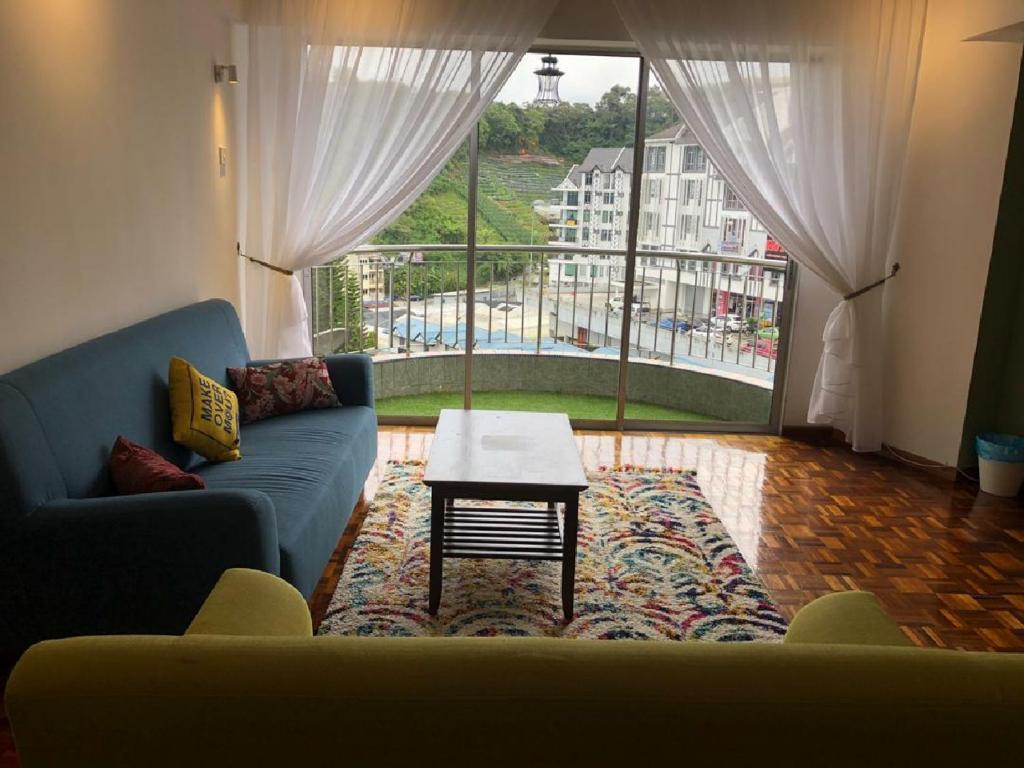 sala de estar con sofá, mesa y ventana en Amy Home Moonlight APARTMENT en Brinchang