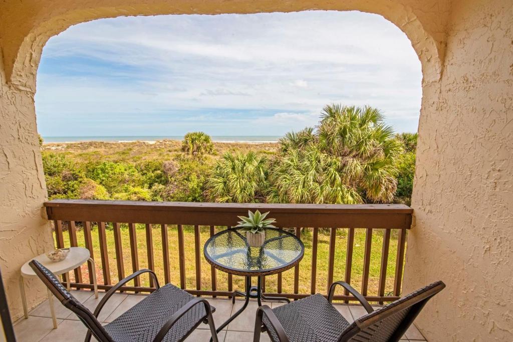 uma mesa e cadeiras numa varanda com vista para o oceano em Unit 8213 - Ocean & Racquet Resort em Saint Augustine Beach