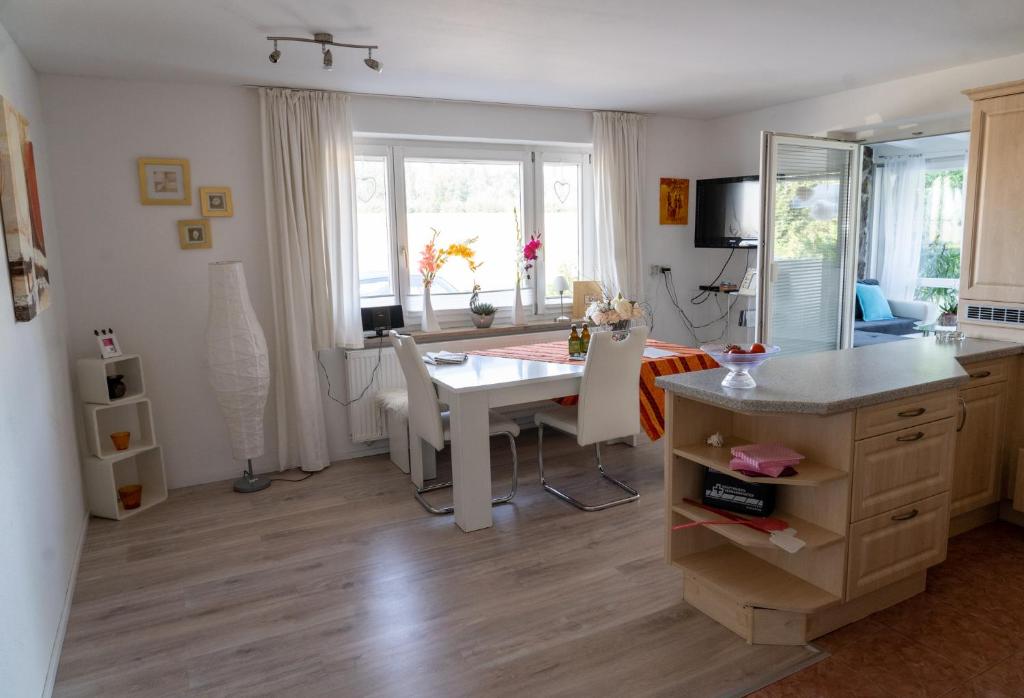 uma cozinha e sala de jantar com mesa e cadeiras em Ferienwohnung im Idyll 1 em Hengersberg