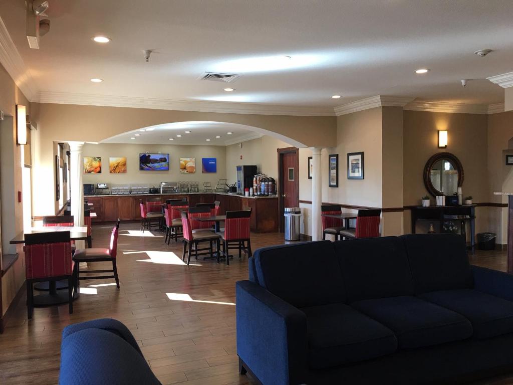 a living room with a couch and tables and chairs at Comfort Inn Early Brownwood in Early