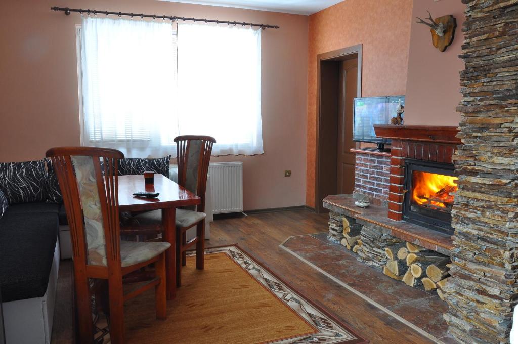 a living room with a table and a fireplace at Guest House Eli in Sapareva Banya