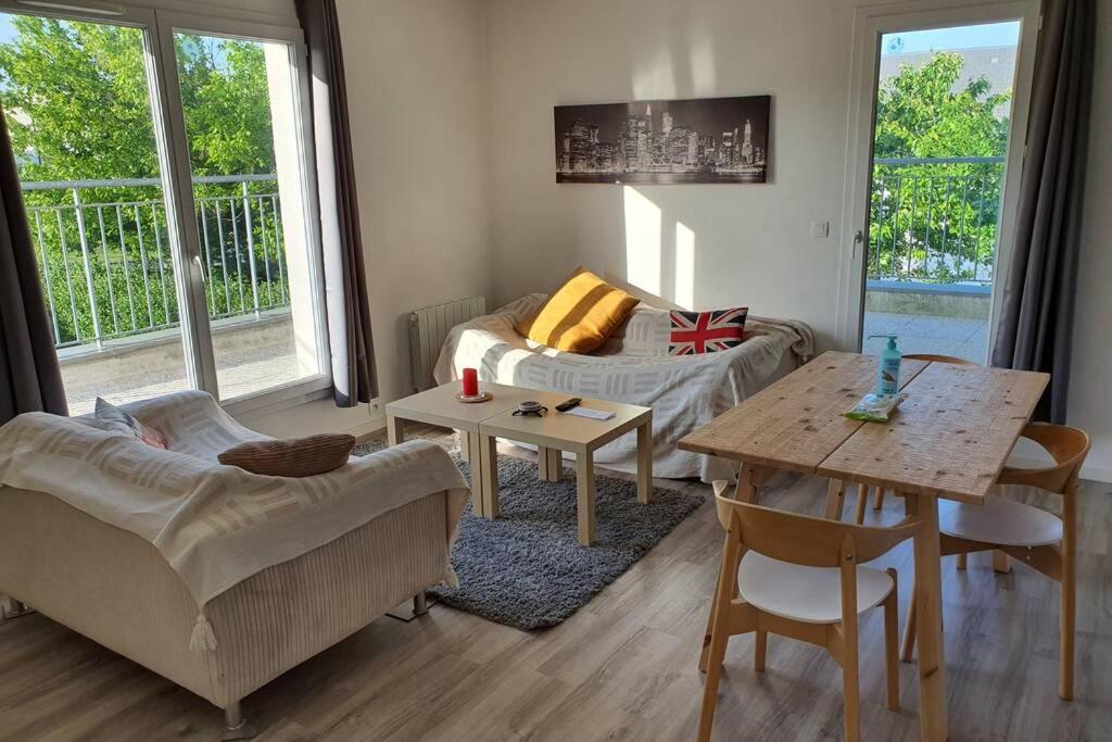 - un salon avec un canapé et une table dans l'établissement Appartement contemporain rénové à neuf avec cuisine équipé - Val de reuil, à Val de Reuil