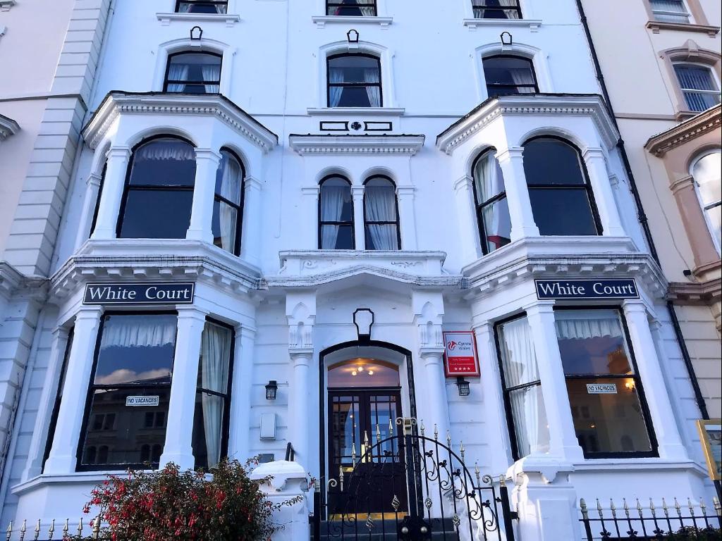 a white building with a white courtartment at White Court Llandudno in Llandudno