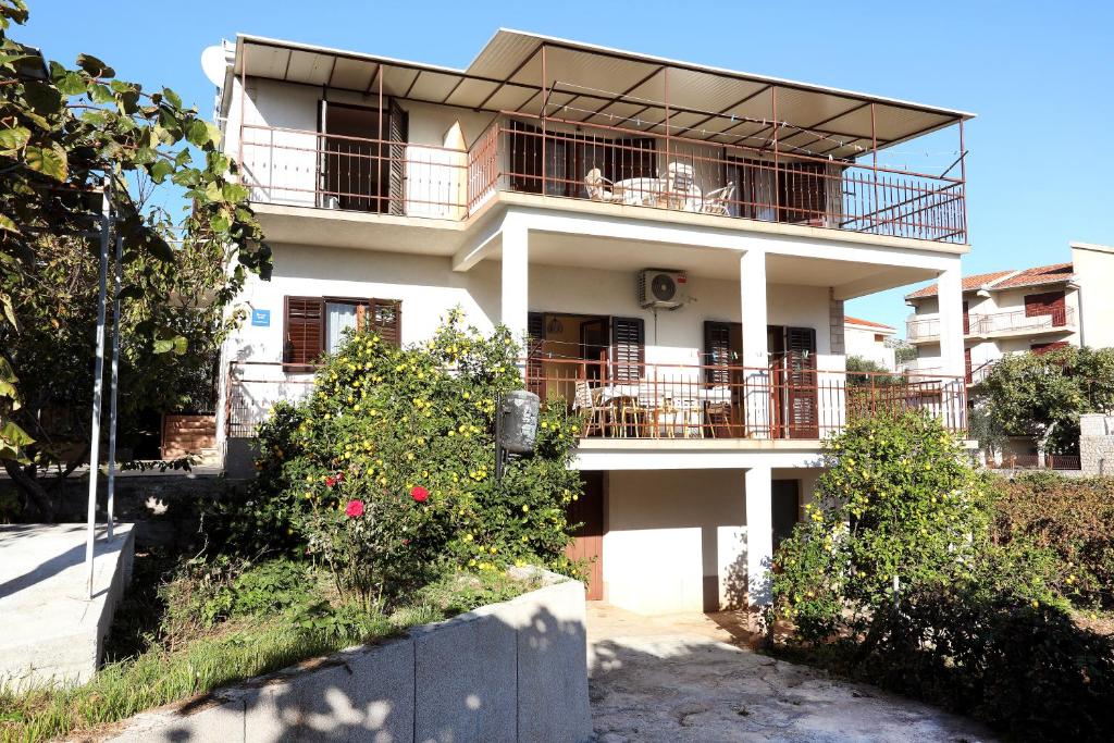a large white building with a balcony on it at Apartman Gilan in Seget Vranjica