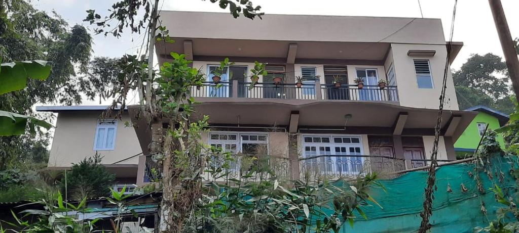 a house with people on the balcony of it at Seven Hills Homestay in Kalimpong
