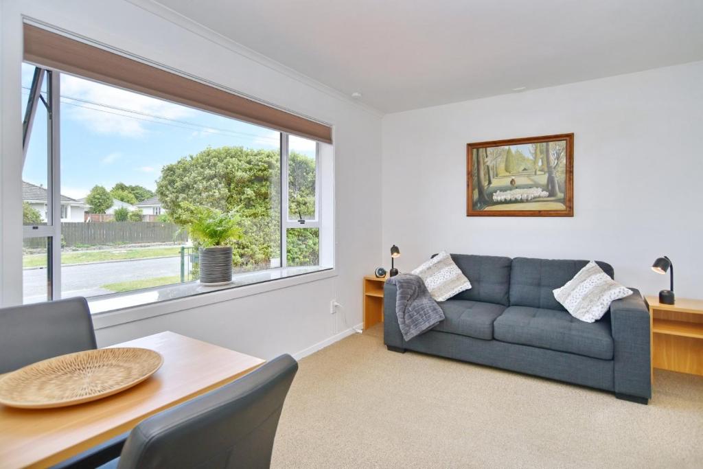 a living room with a couch and a table at Bevington - Christchurch Holiday Homes in Christchurch