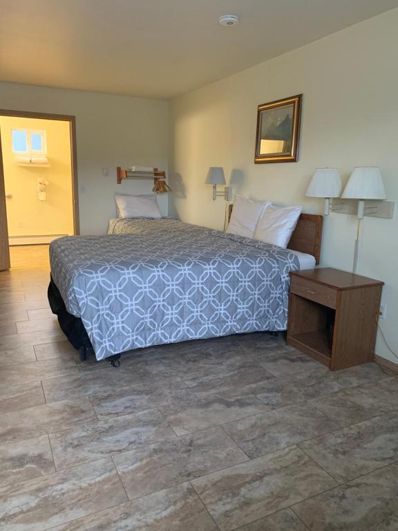 a bedroom with a large bed and a table at Marina Motel in Seward