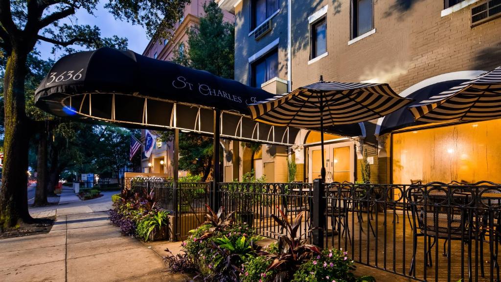 ein Café mit einem Sonnenschirm, Tischen und Stühlen in der Unterkunft St Charles Inn, Superior Hotel in New Orleans