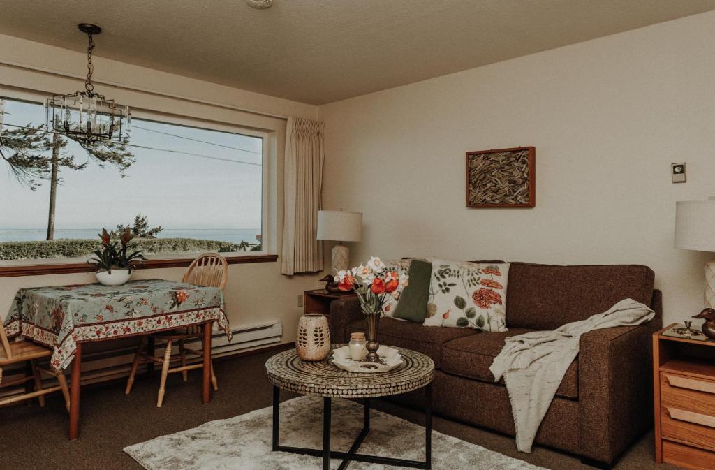 sala de estar con sofá, mesa y ventana en Dungeness Bay Cottages en Sequim