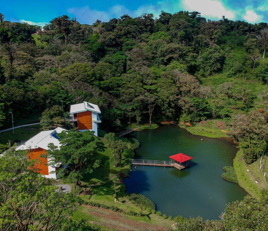 an aerial view of a lake with houses and a dock at Burbi Lake Lodge Monteverde in Monteverde Costa Rica