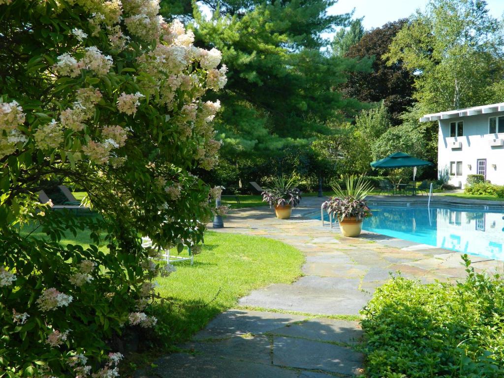 um jardim com piscina e plantas floridas em Paradise Inn em Bennington