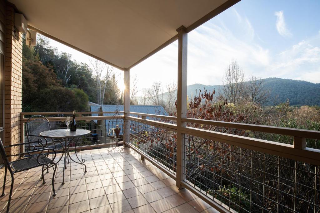 a balcony with a table and a view of the mountains at Chestnut Tree Holiday Units in Bright