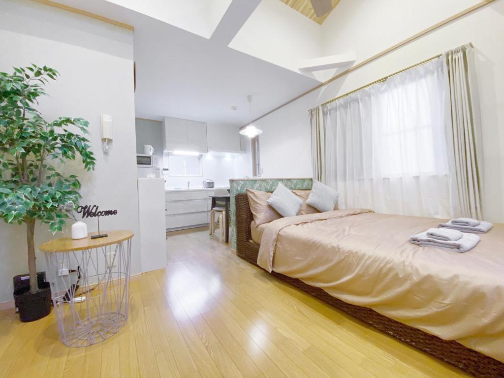a bedroom with a bed with a window and a table at nestay villa tokyo takanawa in Tokyo