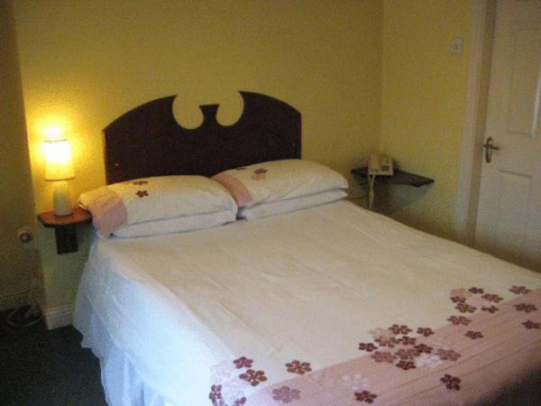 um quarto com uma cama grande com flores em The Anchorage Guest House em Waterford