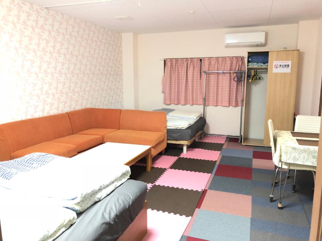a hospital room with a couch and a table at Shoyaya Hostel in Osaka