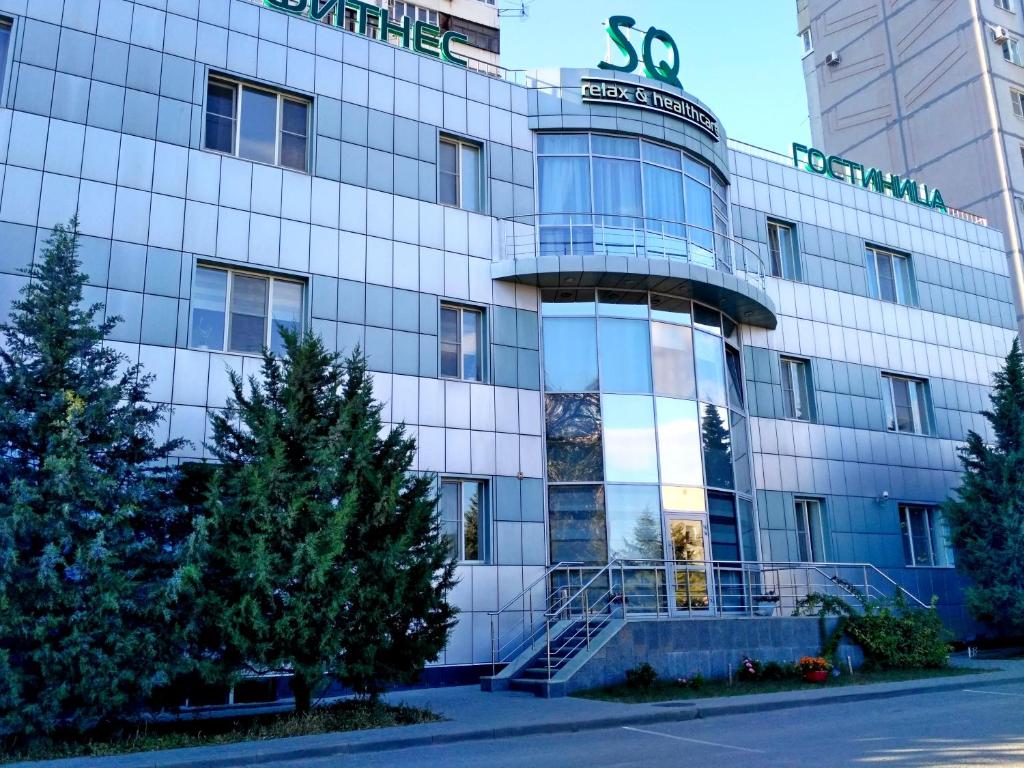 an office building with trees in front of it at SQ Hotel in Volgograd