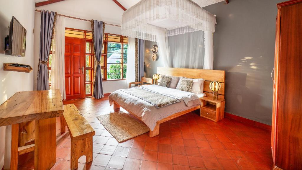 恩德培的住宿－Kisubi Forest Cottages，一间卧室配有一张床和一张桌子