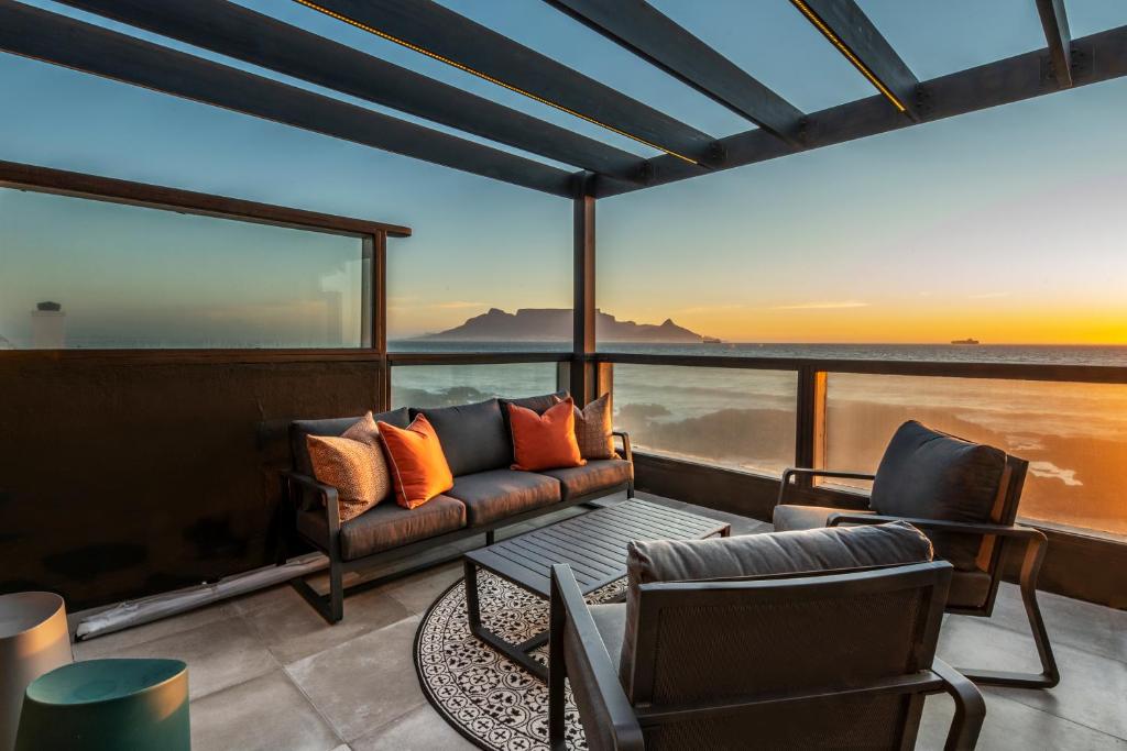 a living room with a couch and chairs on a balcony at Belle Maroc Boutique Hotel in Bloubergstrand