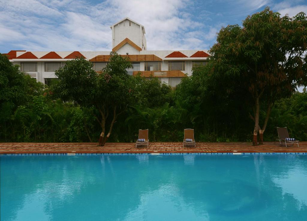 a large swimming pool in front of a hotel at Sarovar Portico Sasangir in Sasan Gir