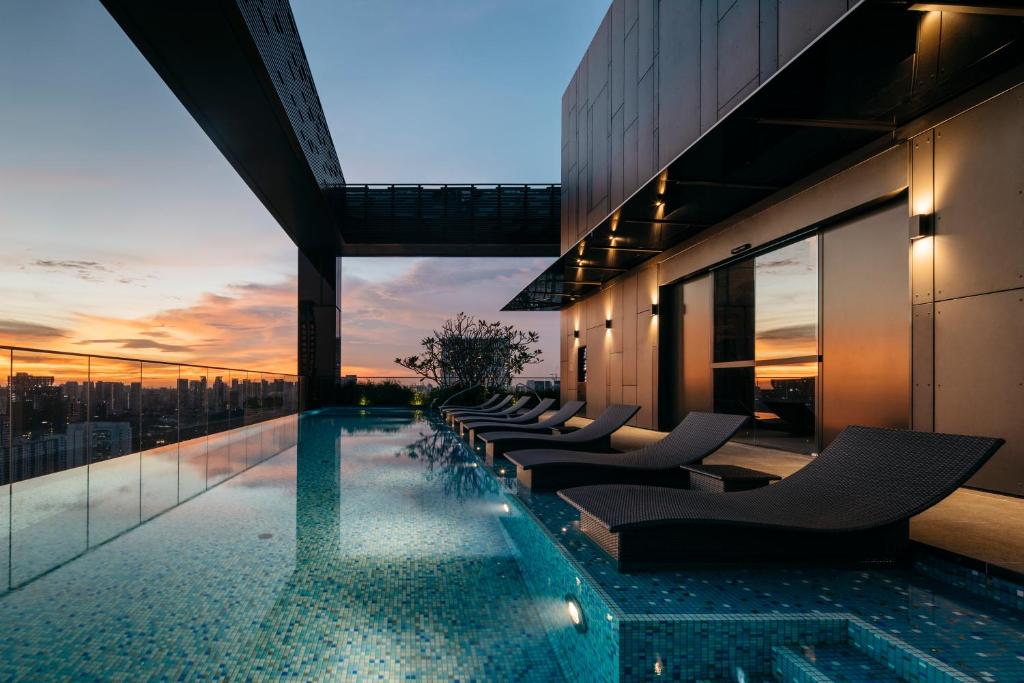 a pool on the roof of a building with chairs at The Clan Hotel Singapore by Far East Hospitality in Singapore