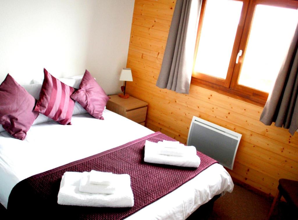 een slaapkamer met een bed met twee handdoeken erop bij Appartement de 2 chambres a Thollon les Memises a 500 m des pistes avec vue sur le lac et wifi in Thollon