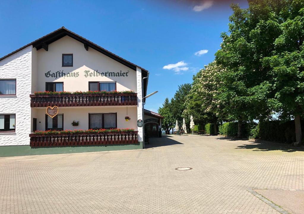 um edifício branco com flores ao lado em Gasthaus Felbermaier em Lampertshofen