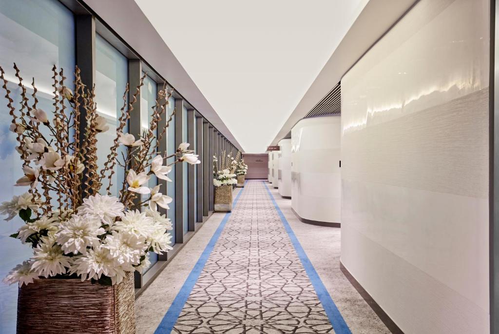 a corridor with flowers on the side of a building at Aerotel Muscat - Airport Transit Hotel in Muscat