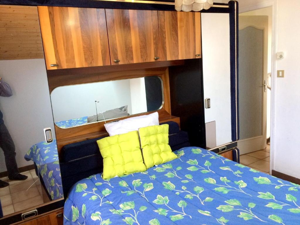 RochessonにあるAppartement de 2 chambres avec terrasse et wifi a Rochesson a 6 km des pistesのベッドルーム(青いベッド、黄色い枕付)