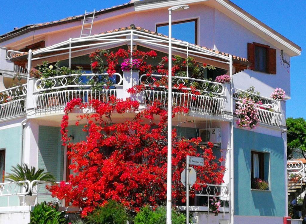 ein Haus mit roten Blumen auf der Seite in der Unterkunft Studio with balcony and wifi at Villacidro in Villacidro