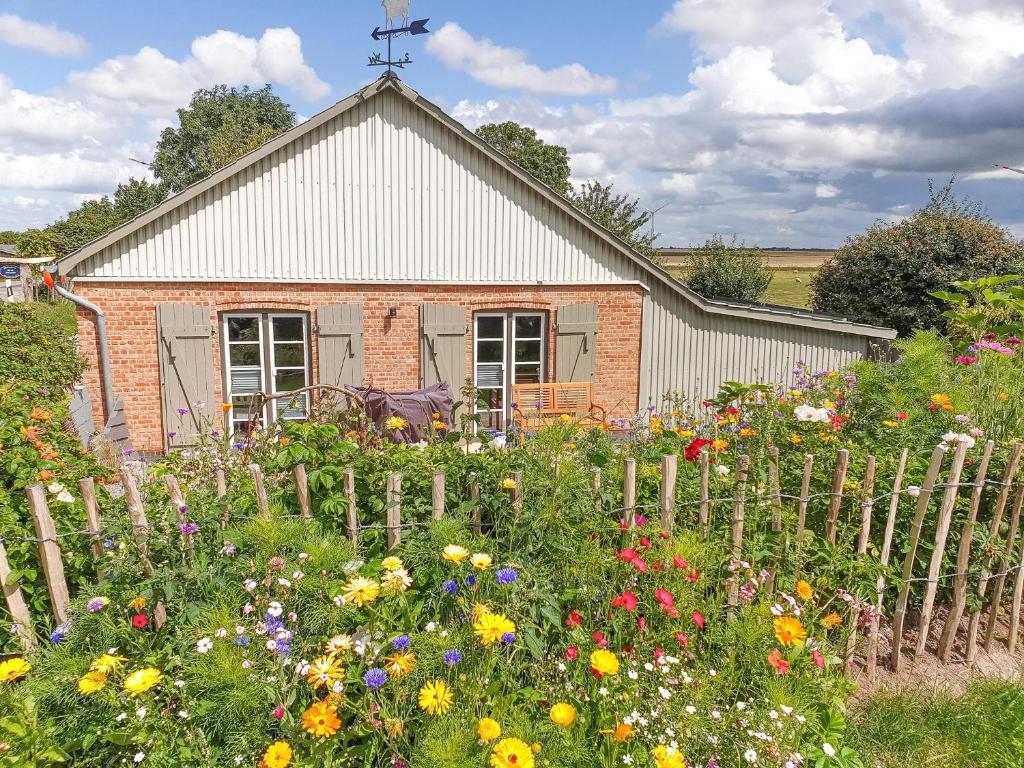 a garden with flowers in front of a building at De ole Schaapstall in Dagebüll