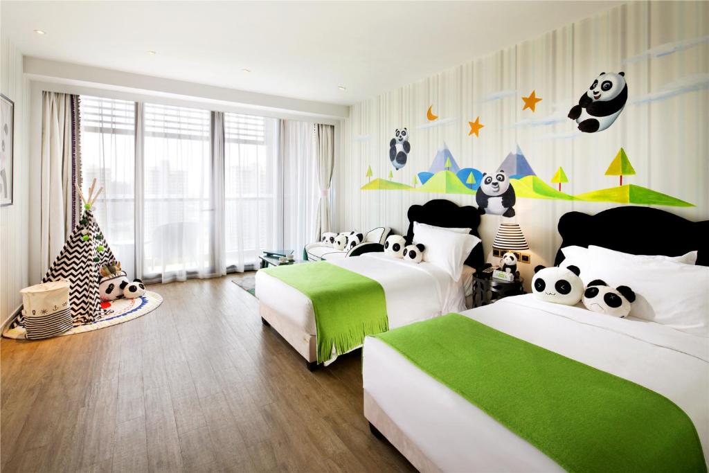 a panda themed bedroom with two beds and a christmas tree at Mangrove Tree Resort World Sanya Bay -Elader Palm Tower in Sanya