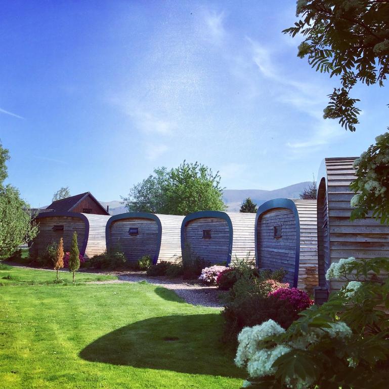 a garden with a fence with four portable toilets at Whitemoss Lodge in Dunning
