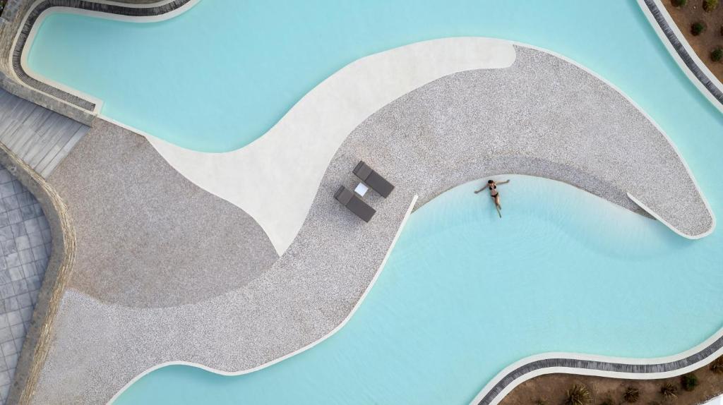 una vista aérea de una persona parada frente a una ola en Summer Senses Luxury Resort en Logaras