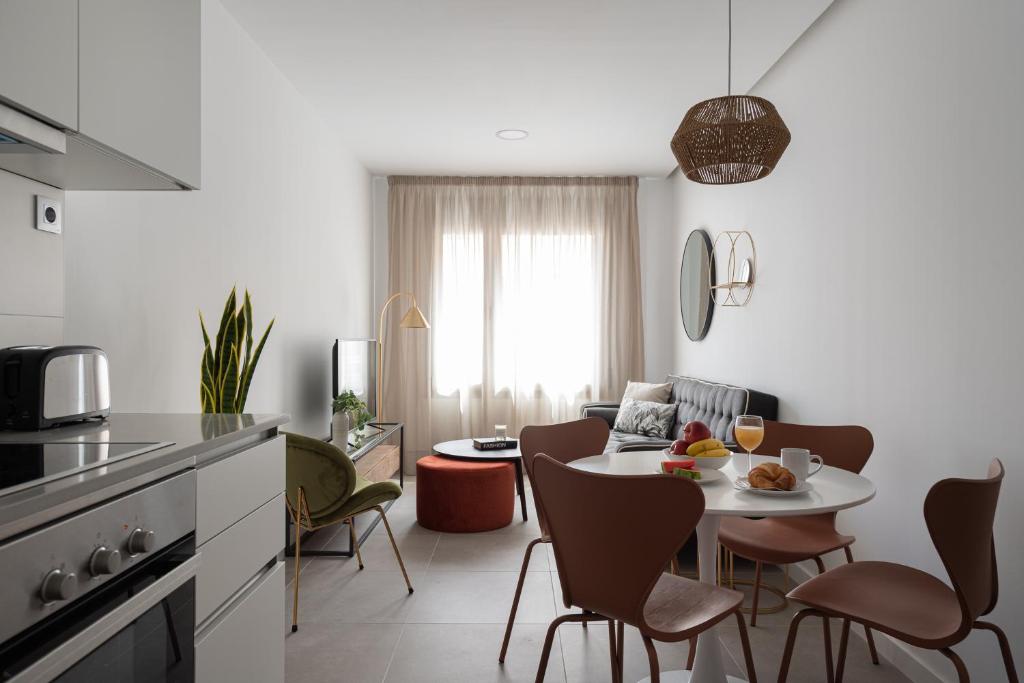 a kitchen and living room with a table and chairs at Royal Flats in Las Palmas de Gran Canaria