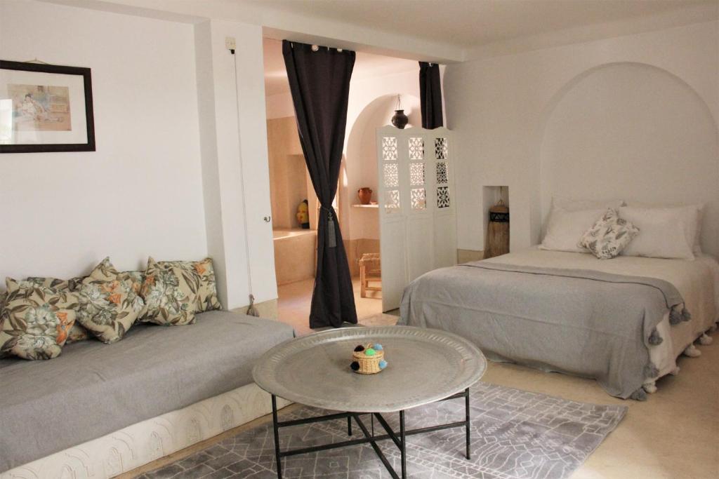 Riad El Ouarda في مراكش: غرفة معيشة مع سرير وطاولة
