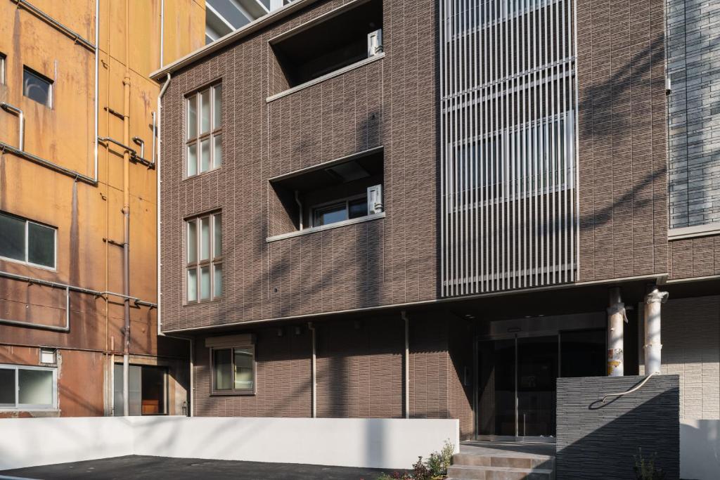 長崎的住宿－GRAND BASE Urakami，一面设有窗户的砖砌建筑
