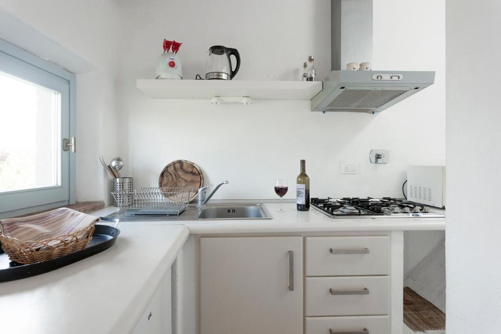 a white kitchen with a sink and a stove at Poderi in Chianti in Tavarnelle in Val di Pesa