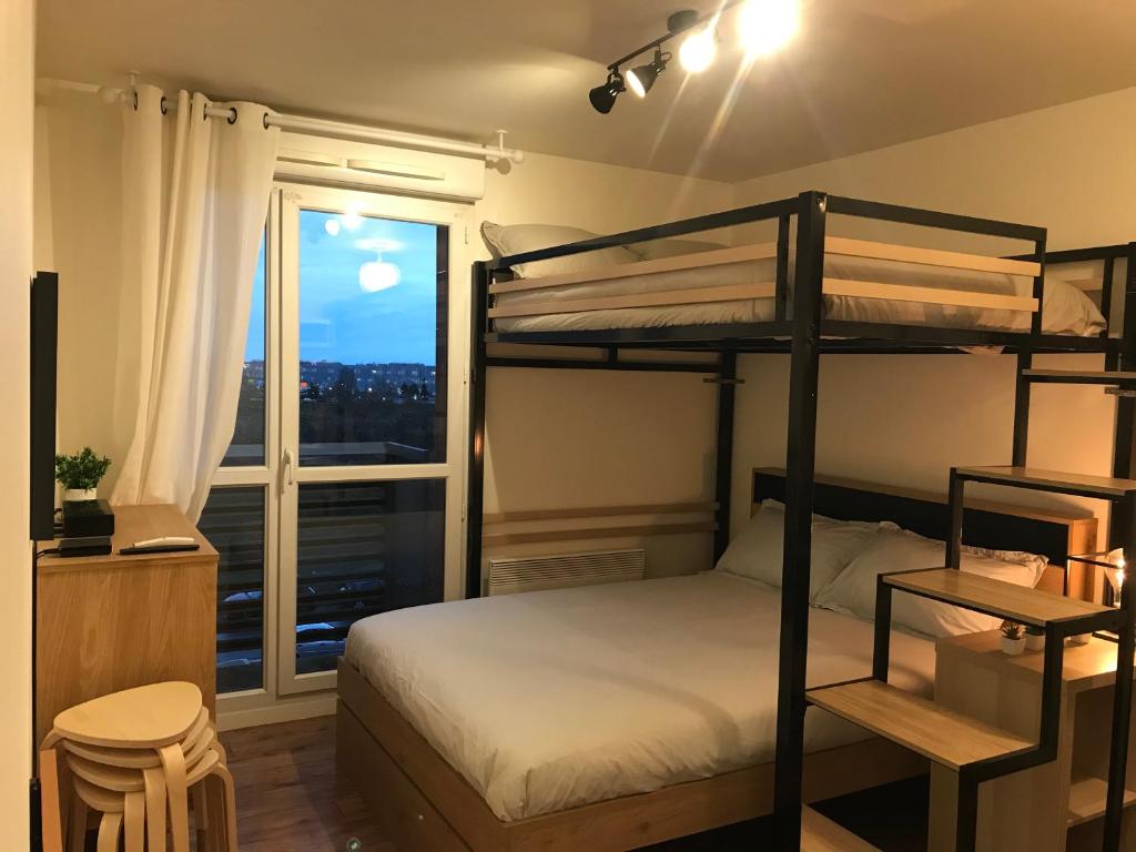 - une chambre avec des lits superposés et une fenêtre dans l'établissement Studio cosy Disney/Paris. RER Val d’Europe à 150m, à Montévrain