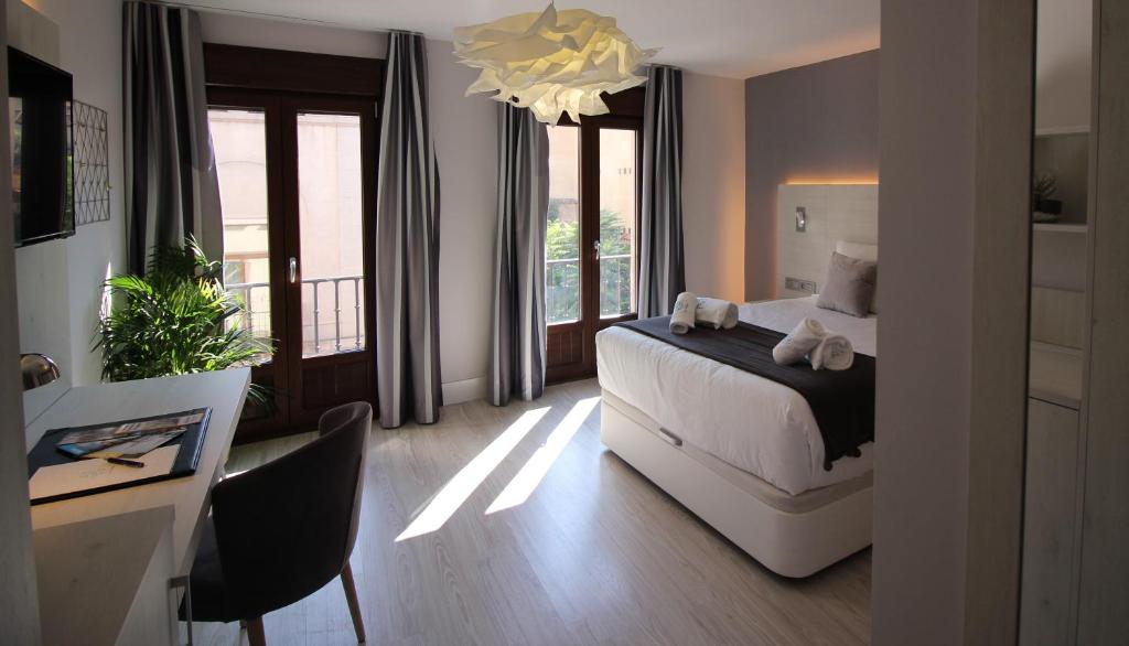a bedroom with a bed and a large window at Palacio La Floresta in Segovia
